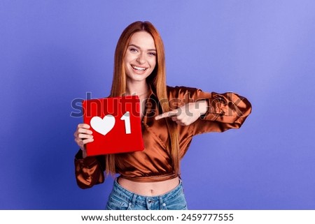 Photo of pretty young woman point finger like notification icon wear brown shirt isolated on violet color background