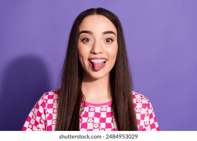 Photo of pretty young woman show tongue wear checkered t-shirt isolated on purple color background