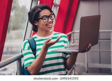 Photo of pretty young woman video call laptop striped t-shirt backpack work study business center office - Powered by Shutterstock