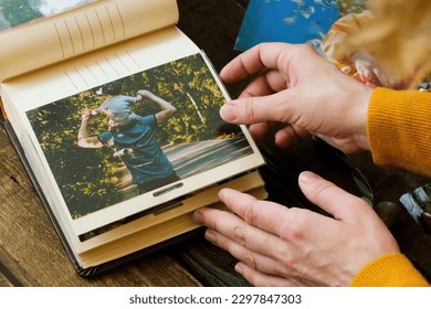 Photo printing. Young woman adding printed photo to family picture album. - Powered by Shutterstock