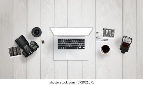 Photo processing on laptop with isolated display for mock up. Camera, lens, flash light, memory card, photos on desk. - Powered by Shutterstock