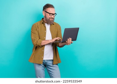 Photo of professional experienced programmer coder man hold his netbook wear eyeglasses concentrated remote worker isolated on cyan color background - Powered by Shutterstock