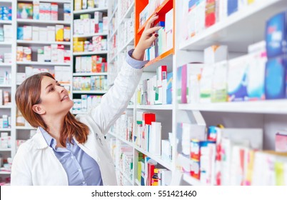 Photo Of A Professional Pharmacist Checking Stock In An Aisle Of A Local Drugstore.