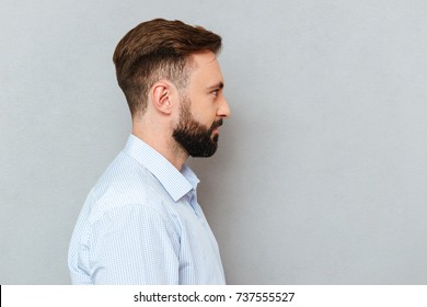 Photo In Profile Of Bearded Man In Business Clothes Posing Over Gray Background