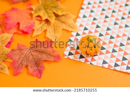 Photo of pumpkin, autumn leaves, Chiyogami paper and orange background