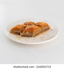 Photo Of Ramadan Baklava With Walnuts Isolated On White Background. Side View Of 4 Slices Of Local Turkish Dessert On A White Plate