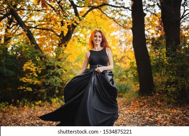 Photo Of Redhead Woman In Black Dress With Fluffy Skirt. Running Towards Camera.