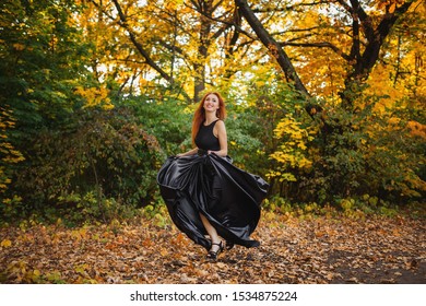 Photo Of Redhead Woman In Black Dress. Running Towards Camera.