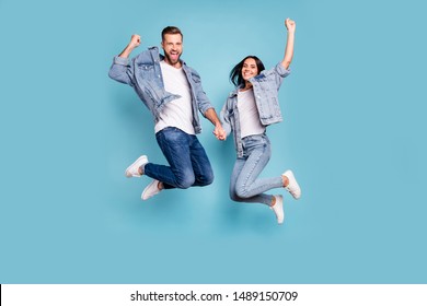 Photo of rejoicing overjoyed nice charming couple wearing jeans denim jackets enjoying their free time in summer while isolated with blue background