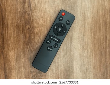 photo of remote control from top angle, remote control is placed on a wooden table - Powered by Shutterstock