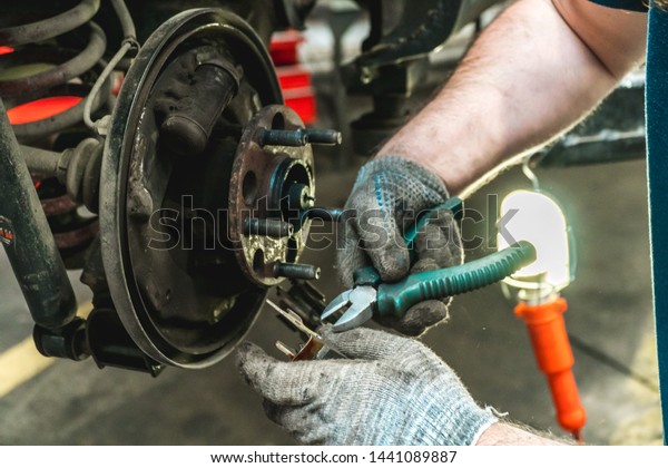 Photo of repair of a running gear of the car\
mechanic\'s hands