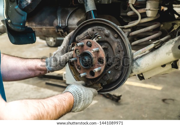 Photo of repair of a running gear of the car\
mechanic\'s hands