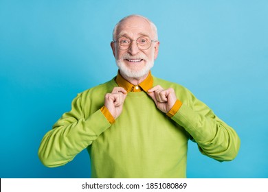 Photo Of Retired Old Man Arms Hold Collar Toothy Smile Wear Glasses Green Pullover Isolated Blue Color Background