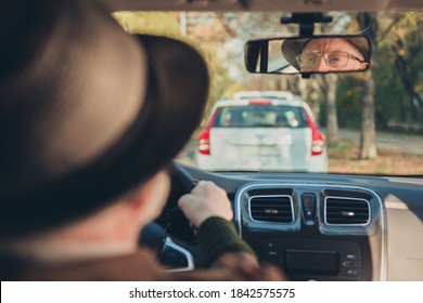 Photo Of Retired Old Man Drive Sit Seat Reflecting Rare View Mirror Look Road Wear Brown Jacket Headwear Spectacles Inside Car