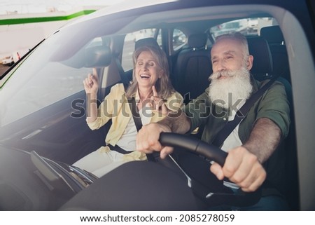 Photo of retired pensioner grey haired people old couple ride car trip good mood sing vacation outside outdoors in urban city