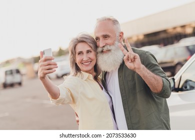Photo of retired pensioner married people wife husband grey haired old couple selfie v-sign card park outside outdoors in urban