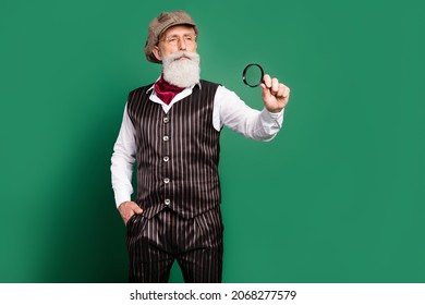 Photo of retro style victorian inspector hold loupe watch wear cap glasses striped suit scarf on green color background