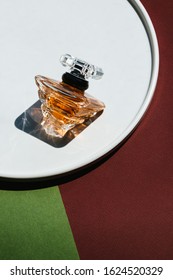 Photo of a rich luxury perfume cologne water on wonderful color geometric background with sunlight and harsh shadows