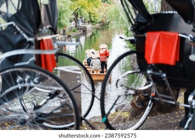 A photo of a rickshaw and riverboat in the tourist town of Kurashiki, with the word 