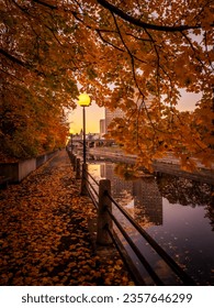 Photo of the Rideau Canal during Fall with leaves on pathway and illuminated lamppost, Ottawa, Ontario, Canada. Photo taken in October 2022. - Shutterstock ID 2357646299