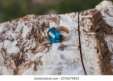 Photo Of A Ring Made Of Epoxy Resin Lying On A Texture Cut Of A Tree. Eco-friendly Material To Create Beautiful Things. Bright Unusual Gift For A Girl. Epoxy Resin Is Often Used For Decor.