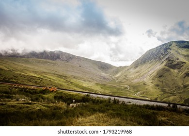 Photo Of The Rolling Hills Of Snowdonia With A Train Track Running Through It.