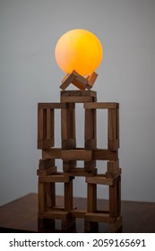 Photo Of A Round Glowing Yellow Ball On Brown Wooden Blocks.