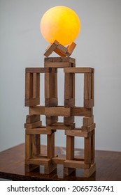 Photo Of A Round Glowing Yellow Ball On Brown Wooden Blocks.