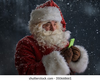 Photo Of Santa Claus Using Mobile Phone Outdoors Under Snow 