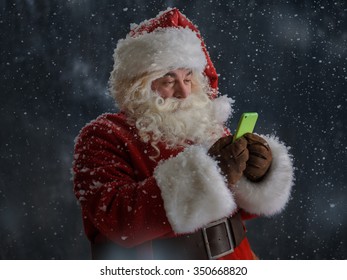 Photo Of Santa Claus Using Mobile Phone Outdoors Under Snow 