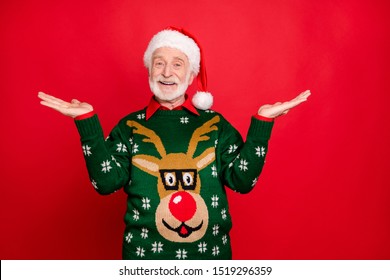 Photo Of Santa Senior Man Holding Sale Products On Open Palms Advising Low Holiday Prices Wear X-mas Ugly Ornament Sweater Isolated Red Background