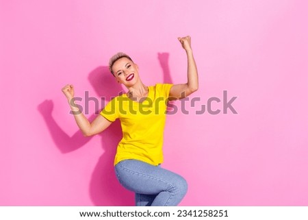 Photo of satisfied cheerful good mood girl raise fists triumph luck isolated on pink color background