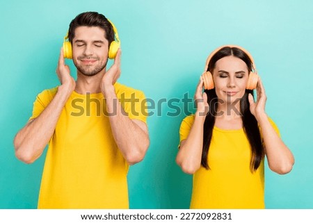 Photo of satisfied good mood two people closed eyes touch wireless headphones chill listen soundtrack melody isolated on aquamarine color background