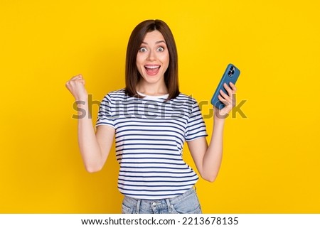 Photo of satisfied lady scream yeah arm raise hold telephone rejoice modern gadget device sale isolated on yellow color background