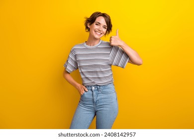 Photo of satisfied nice woman dressed striped t-shirt showing thumb up good work arm in pocket isolated on yellow color background - Powered by Shutterstock