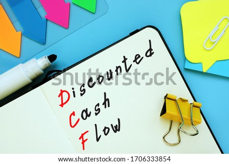 The photo says Discounted Cash Flow DCF. Notepad, pen, marker.