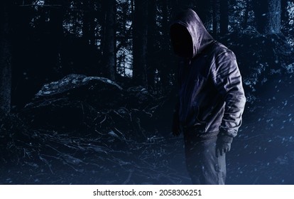 Photo Of Scary Horror Stranger Stalker Man In Black Hood And Clothing On Forest Background.