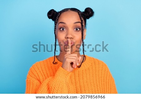 Photo of secret young lady finger mouth wear knit orange sweater isolated on blue color background