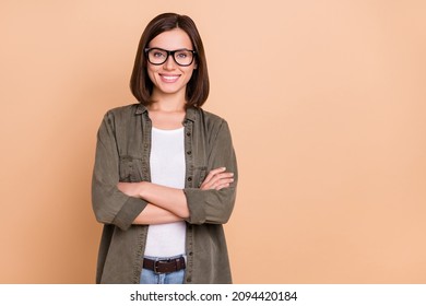 Photo of self-assured freelancer lady crossed arms wear eyeglasses khaki shirt isolated beige color background