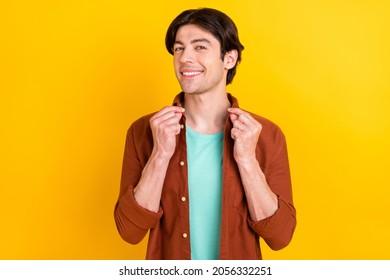 Photo Of Selfish Pretty Young Guy Dressed Brown Shirt Arms Hands Collar Smiling Isolated Yellow Color Background