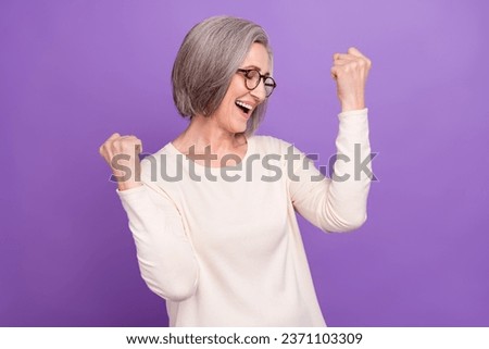 Photo of senior excited company admin wear white shirt raised fists up hooray celebration her promotion isolated on purple color background