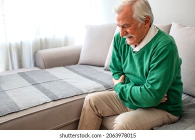 Photo Of Senior Man With Stomach Pain. Senior Caucasian Gray Hair Man Stomachache, Pressing On Stomach With Painful Expression. Dehydration Commonly Has A Role In Stomach And Abdominal Pains