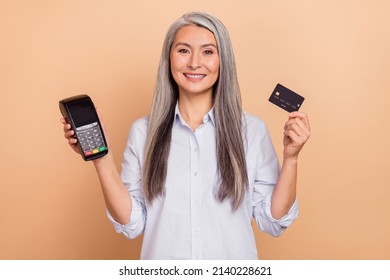 Photo Of Senior Woman Hold Bank Card Store Payment Promo Finance Isolated Over Beige Color Background