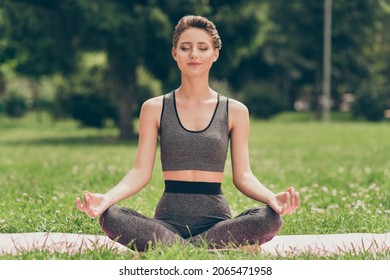 Photo of serene sincere peaceful sportswoman sit mat do yoga wear grey top nature park garden outdoors - Powered by Shutterstock