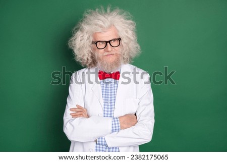 Photo of serious cool confident mad scientist look copyspace crossed arms crazy physician isolated on green color background