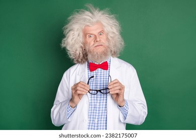 Photo of serious funky funny mad crazy physician with messy hair hold glasses isolated on green color background - Powered by Shutterstock