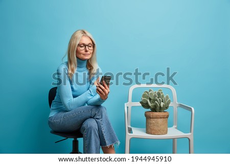 Similar – Image, Stock Photo A middle-aged woman, alone, watches television, looking sad