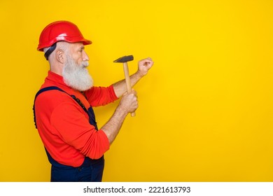 Photo of serious professional old guy dressed uniform overall red hardhat hummer in nails empty space isolated yellow color background - Powered by Shutterstock