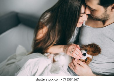 A Photo Session Of A Guy And A Girl In A Cozy Home Environment. A Family Member Is A Little Dog.