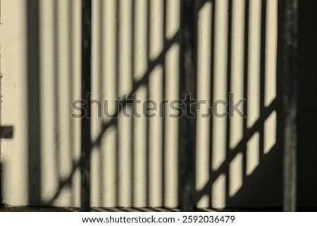 Photo of shadow lines of the home or house fence on the beige or yellow wall. silhouette.